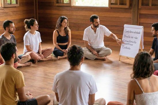 Facilitador explica combinados ao grupo em roda, reforçando consentimento e limites no Tantra.