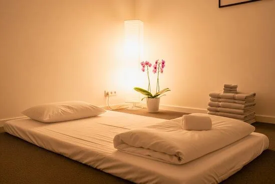 Sala de atendimento organizada, com terapeuta preparando o espaço, simbolizando a ética na relação terapêutica em trabalhos corporais e energéticos.