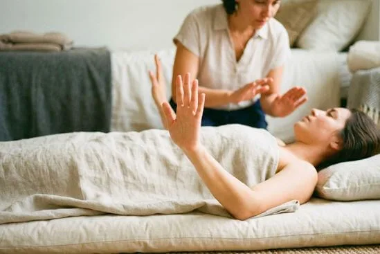 Mão levantada em gesto de limite durante atendimento, reforçando consentimento na primeira sessão de massagem tântrica.